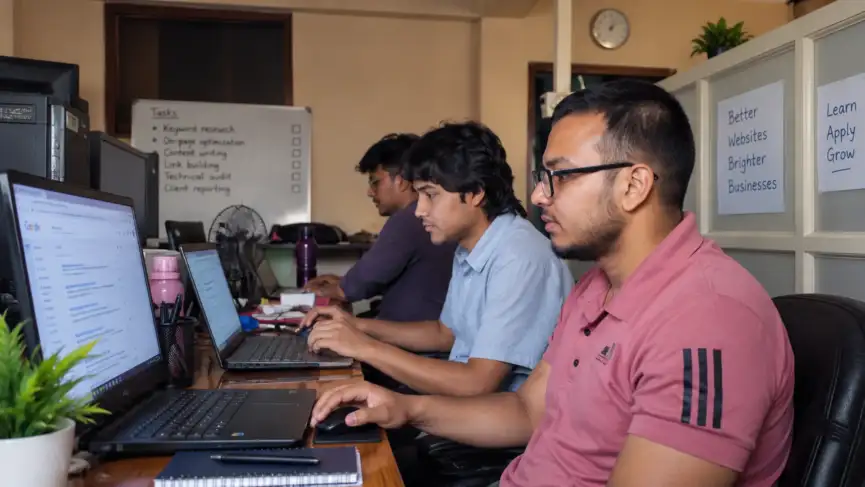 SEO Course In Nepal featuring professionals practicing SEO techniques on computers in an office workspace.